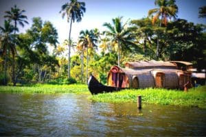 Under the coconut trees, a houseboat in the water canal