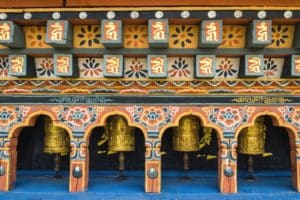 Spin Bhutanese Buddhist pray wheels at Chimi Lhakang Monastery to recite prayers on your Bhutan holiday tours.