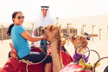 Tourist riding a camel in Dubai